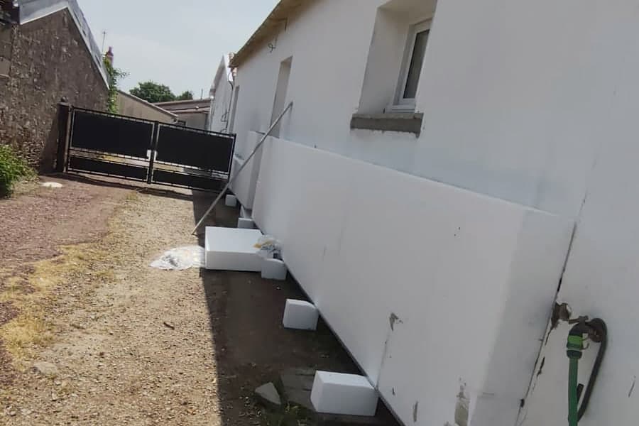 Panneaux isolants posés le long du mur de la maison, rangée de départ et cales de maintien