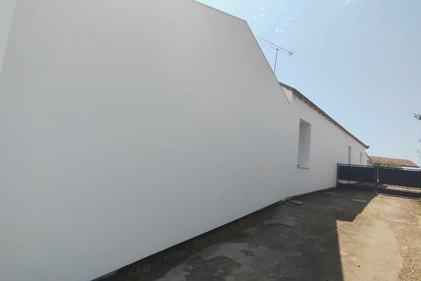 Façade de maison après isolation par l'extérieur et enduit de finition beige, chantier Ouest Façadier